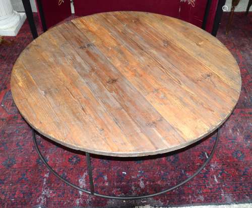 A large round pine table set on a metal base 43 x 124cm.