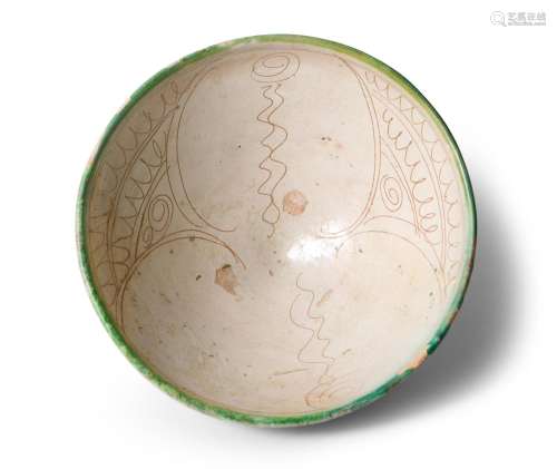 AN EARLY ISLAMIC SGRAFFITO DECORATED EARTHENWARE BOWL GHAZNA...