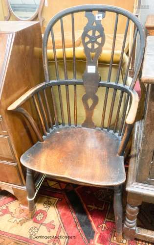An early 19th century elm and ash wheel back elbow chair, wi...