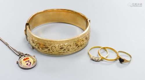 A filled 9ct gold bangle together with a three-stone 18ct ye...