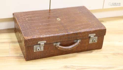 An early 20th century crocodile skin suitcase with blue leat...