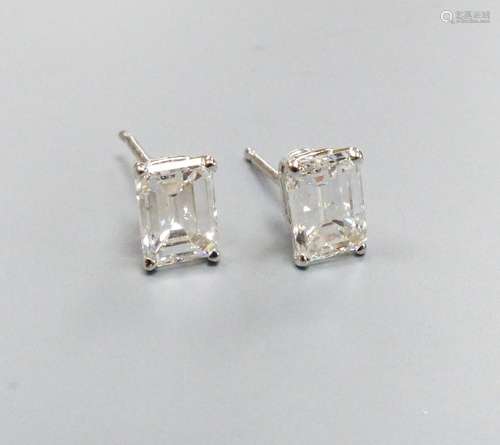 A modern pair of white metal and solitaire emerald cut diamo...