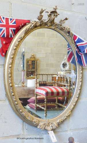 A Victorian oval giltwood and gesso wall mirror, width 61cm,...