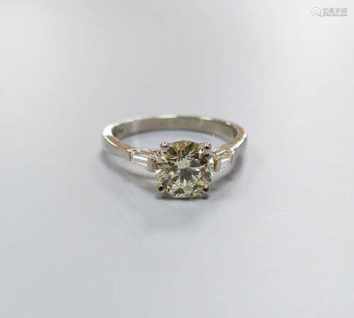 A modern platinum and single stone diamond ring, with trapez...