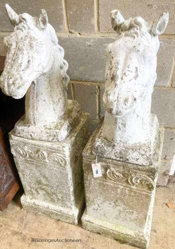 A pair of reconstituted stone horse's heads on plinth bases ...