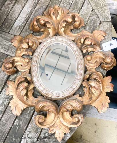 A 1930's Italian carved giltwood oval mirror, width 47cm, he...