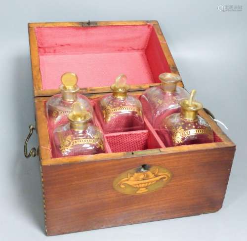 A mahogany inlaid decanter box containing five gilt decorate...