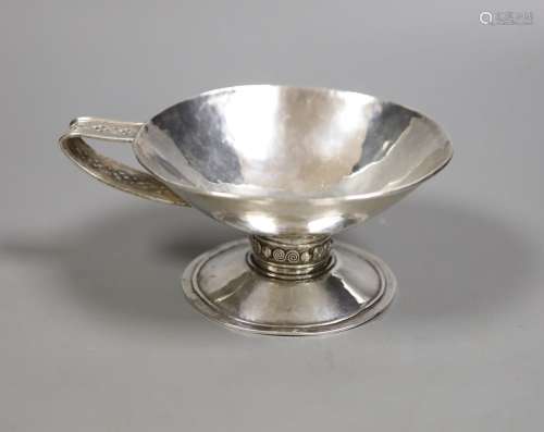 An Arts & Crafts planished white metal single handled pedest...