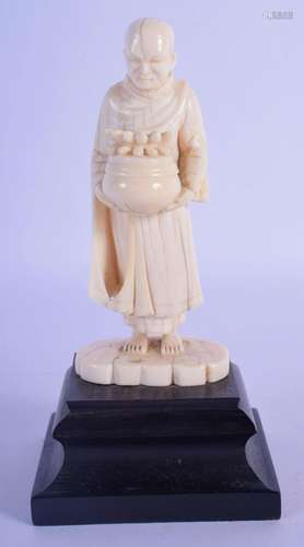 A 19TH CENTURY INDIAN CARVED IVORY FIGURE OF A STANDING BUDD...