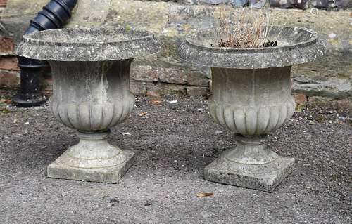 A pair of composition stone urns