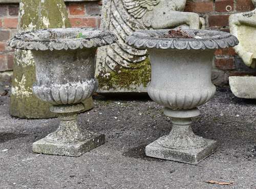 A pair of composition stone urns