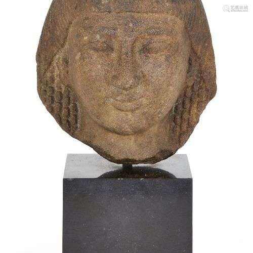 Une tête en quartzite de style égyptien, avec des cheveux bo...