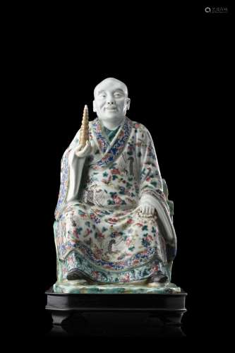 A polychrome porcelain figure depicting a seated sage, wood ...