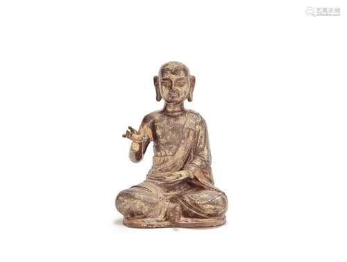 A GILT COPPER ALLOY FIGURE OF A MONK