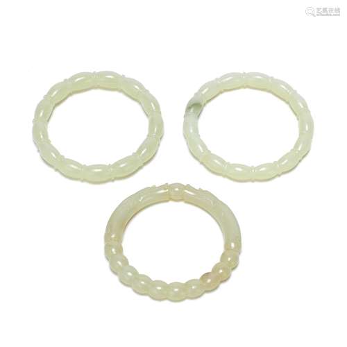 A GROUP OF THREE PALE JADE BANGLES