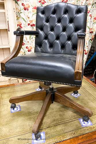 A reproduction beech buttoned blue leather swivel desk chair...