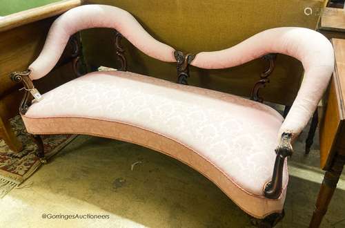 A Victorian walnut love seat, upholstered in floral damask, ...