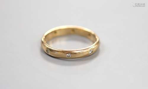 A modern 14k and gypsy set eight stone diamond eternity ring...