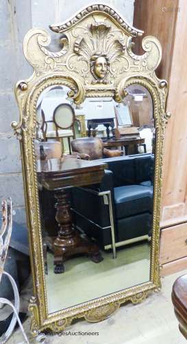 A George I style gilt composition wall mirror, having arched...