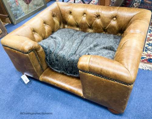 An Italian buttoned tan leather dog's bed with loose cushion...