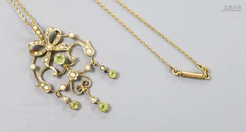 An Art Nouveau 9ct, peridot and seed pearl set scroll pendan...