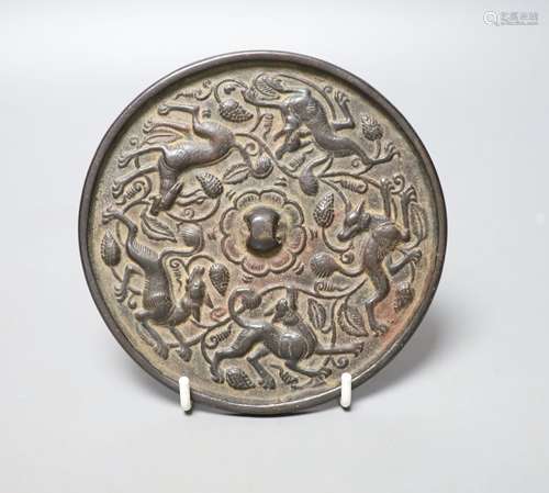 A Chinese bronze mirror, cast with vines and hounds, 14cm