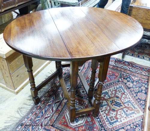 An 18th century style oval oak gateleg table, 100cm extended...