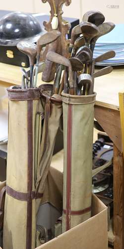 A collection of pre-war golfing irons and woods, contained w...