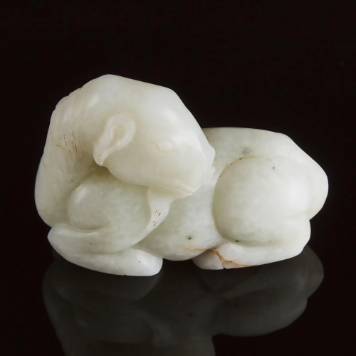 A Mottled White Jade Carving of a Recumbent Ram, Ming