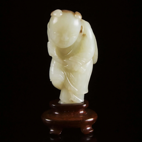 A White and Russet Jade Carving of a Boy Holding
