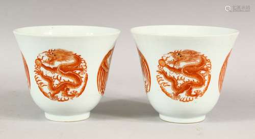 A PAIR OF RED AND WHITE CUPS, each with four panels of drago...