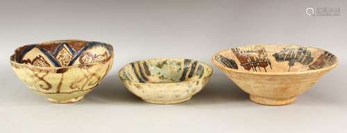 THREE EARLY ISLAMIC POTTERY BOWLS, largest 24cm diameter.