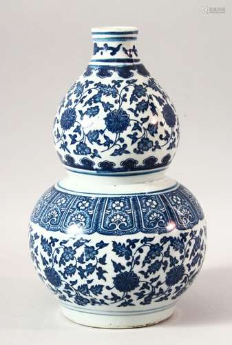 A CHINESE BLUE AND WHITE DOUBLE GOURD VASE, painted with lot...