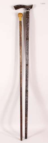 TWO WOODEN INDIAN WALKING STICKS - the larger with white met...