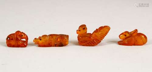 FOUR CHINESE CARVED AMBER MINIATURE ANIMALS, largest 3cm lon...