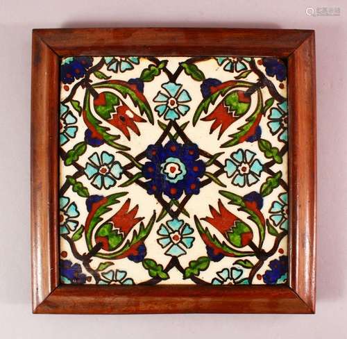 A FRAMED IZNIK STYLE POTTERY TILE SECTION, with a floral mot...