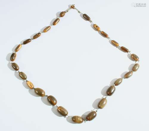 A HORN BEAD NECKLACE, possibly rhino horn, comprising 26 gra...