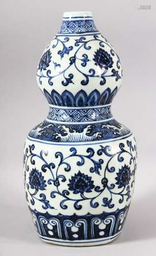 A CHINESE BLUE AND WHITE DOUBLE GOURD VASE, painted with lot...