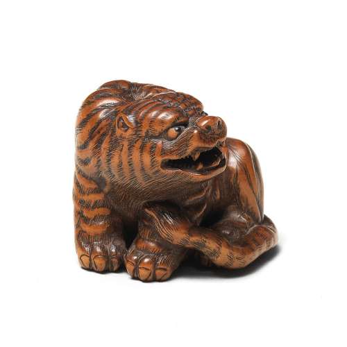 A WOOD NETSUKE OF A TIGER