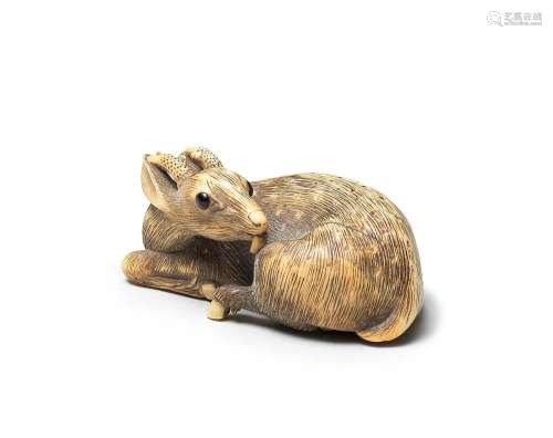 An ivory netsuke of a recumbent deer