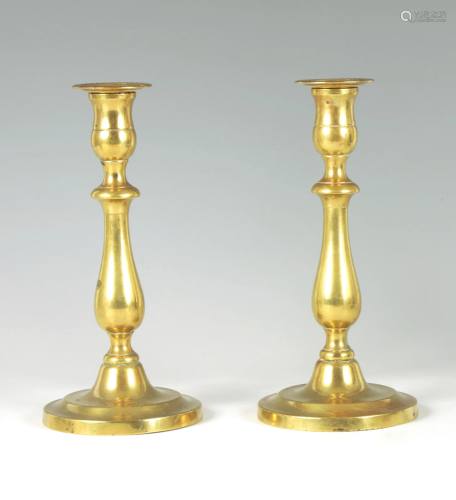 A PAIR OF 18TH CENTURY CIRCULAR BASE BRASS CANDLESTICKS