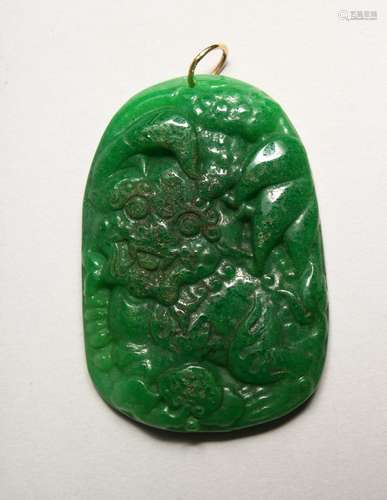 A CHINESE CARVED GREEN JADE PENDANT with gold ring.