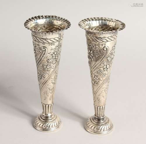 A PAIR OF VICTORIAN SILVER TAPERING VASES with repousse deco...