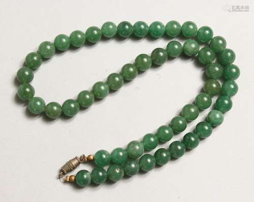 A STRING OF GREEN JADE BEADS