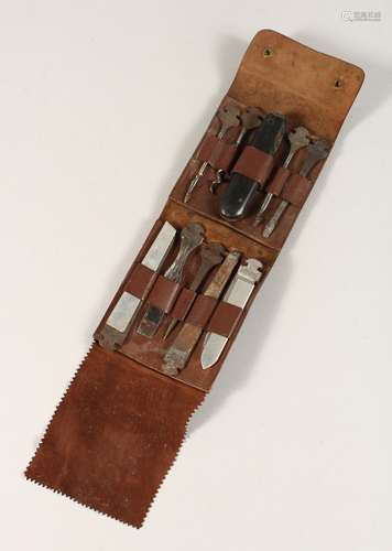 A TRAVELLING BOUSN KNIFE AND TOOLS in a leather folding case