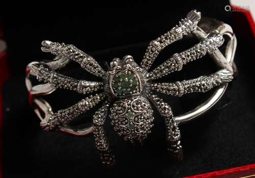 A SILVER EMERALD AND MARCASITE SPIDER BANGLE