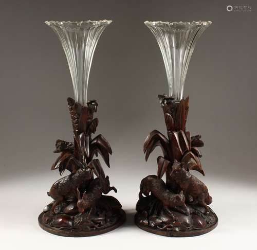 A GOOD PAIR OF BLACK FOREST CARVED WOOD VASE STANDS, one car...