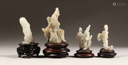 FOUR SMALL CORAL SPECIMENS on a wooden base.