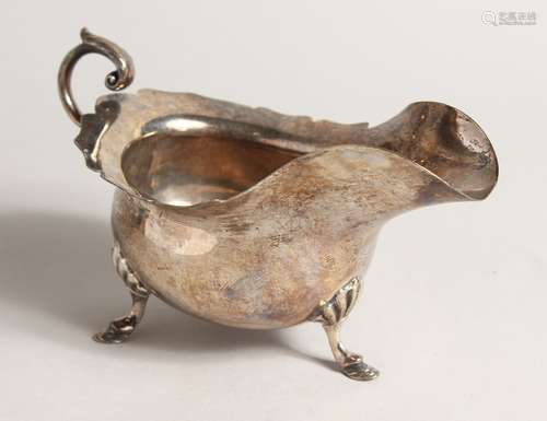 A SILVER SAUCE BOAT, with scroll handle on shell and hoof fe...