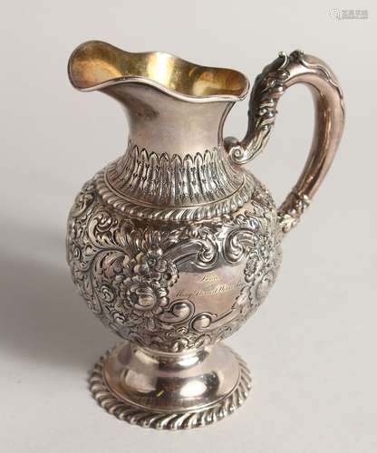 A VICTORIAN SILVER JUG with repousse decoration 6.5ins high